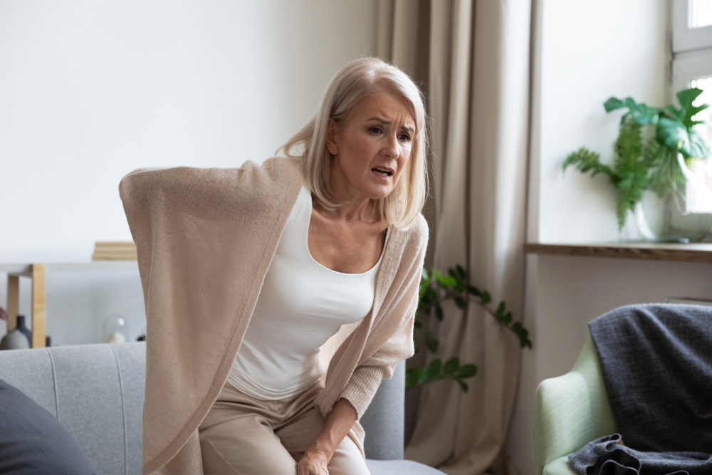 Herniated disc - woman in pain holding her back