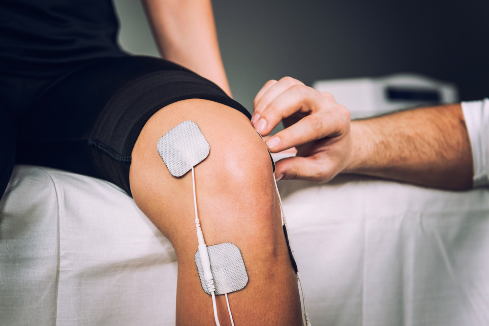 Microcurrent therapy treatment on man's knee