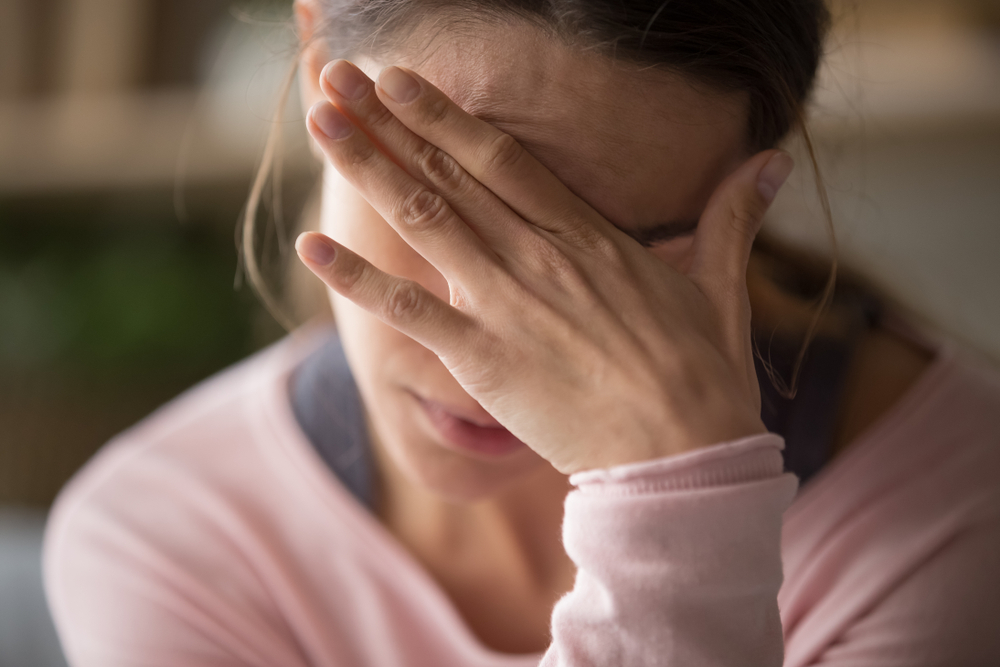 Migraine headache. Woman holding her head.